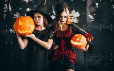 Two girls in halloween costumes in studio